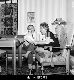 Deutscher Wis und Hörspielsprecher Joseph Offenbachmit Thunfischwadenfänger Frau im Wohnzimmer, Anfang 1960er Jahre. Deutsche Schauspieler Stockfoto