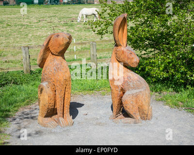 Holz-Skulptur von zwei Hasen von lokalen Kettensäge Bildhauer Steve Iredale in Guisborough Woods North Yorkshire England UK Stockfoto