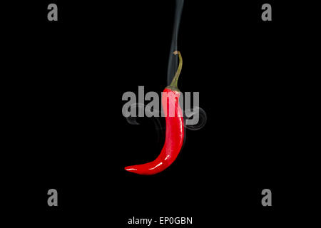 Rauchen red hot Chili peppers. Studioaufnahme von Spice in Luft auf schwarzem Hintergrund mit Rauch schweben hautnah. Stockfoto