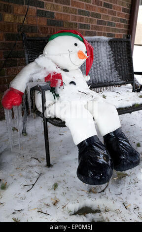 Irritiert, gefüllte Schneemann auf Bank sitzend mit Eiszapfen hängen vom Arm. St Paul Minnesota MN USA Stockfoto