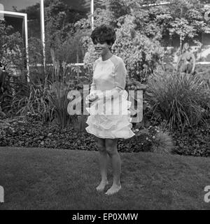 Deutsche Fictitious character Uschi Glas als Sängerin barfuß im Garten der TV-Sendung "Musik aus Studio B", Deutschland 1960er Stockfoto