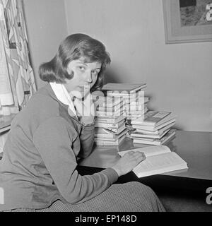 Eine Junge Frau Sitzt Mit Einem Stapel Bücher ein Einem Tisch, 1950er Jahre Deutschland. Eine junge Frau mit einem Stapel von Büchern sitti Stockfoto