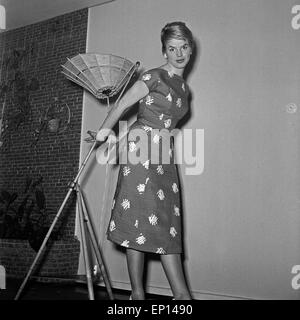 Eine Junge Frau Mit Einer Deckenlampe in Einem APPLELOVE, 1950er Jahre Deutschland. Eine junge Frau mit einer Deckenlampe tragen schön Stockfoto