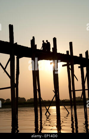 Zwei buddhistische Mönche silhouetted gegen die untergehende Sonne zu Fuß über die U-Bein Brücke Myanmar Stockfoto