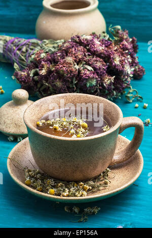 keramische Tasse mit Tee aus getrockneten Kamille und Heilkräuter gebraut. Selektiven Fokus Stockfoto