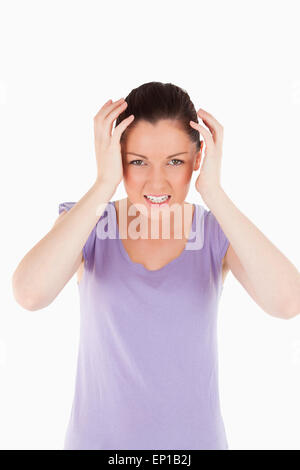 Gut aussehende Frau, die eine Migräne im stehen Stockfoto