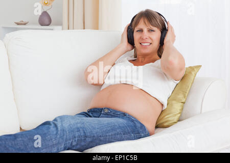 Schwangere Frau anhören von Musik Stockfoto