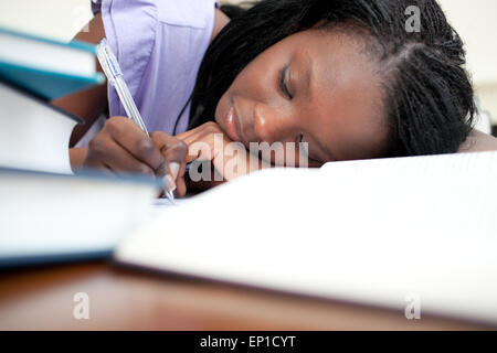 Müde Teengirl ihre Hausaufgaben Stockfoto