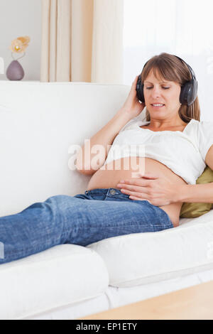 Porträt einer glücklich schwanger Frau anhören von Musik Stockfoto