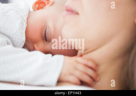 Niedliche Baby schläft auf der Brust der Mutter Stockfoto