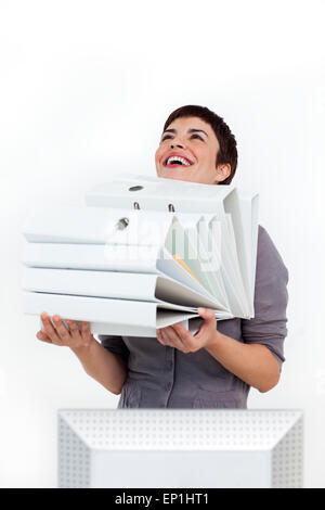 Lachend Geschäftsfrau mit einem Haufen von Ordnern Stockfoto