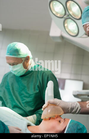 Chirurg setzen eine Maske auf dem Gesicht eines Patienten Stockfoto