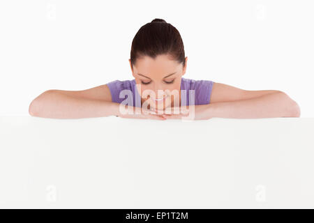 Schöne Frau posiert hinter einer Plakatwand stehen Stockfoto