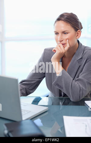 Porträt von einer nachdenklichen Geschäftsfrau mit einem Laptop arbeiten Stockfoto