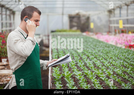 Gärtner aufrufen und Notizen im Gewächshaus Stockfoto