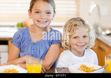 Bruder und Schwester mit Frühstück in der Küche Stockfoto