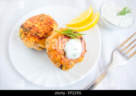 Thai Fisch Kuchen (Schnitzel) mit weißer Sauce, Dill und Zitrone auf Platte Stockfoto