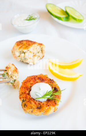 Thai Fisch Kuchen (Schnitzel) mit weißer Sauce, Dill und Zitrone auf Platte Stockfoto