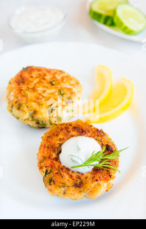 Thai Fisch Kuchen (Schnitzel) mit weißer Sauce, Dill und Zitrone auf Platte Stockfoto