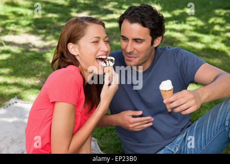 Frau sitzend mit ihrer Freundin Eis essen Stockfoto