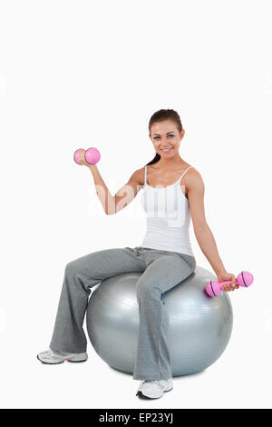 Porträt einer lächelnden Frau Workout mit Hanteln und eine Kugel Stockfoto