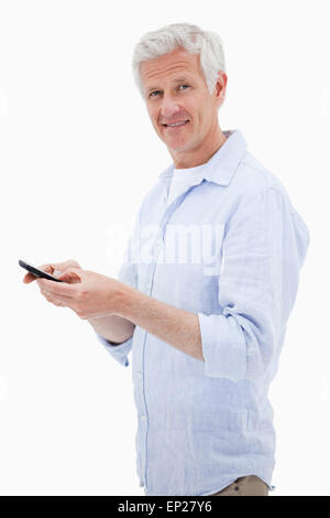 Porträt eines Mannes mit seinem Mobiltelefon beim Betrachten der Kameras Stockfoto