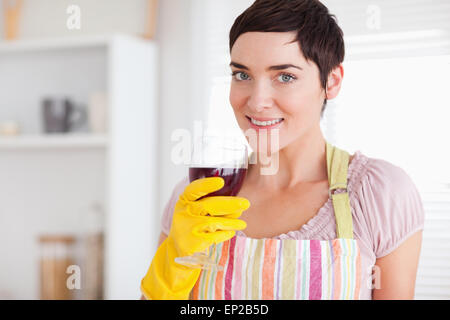 Schöne Frau trinken Wein tragen Reinigung Kleid Stockfoto