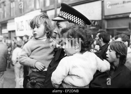 Feuer bei Maryhill Road Glasgow. Feuer bricht in einen unbesetzten Möbelgeschäft Verbreitung entlang der Ladenzeile und fangen einige Familien in ihren Häusern oben. Fünfzig Familien wurden obdachlos, und eine Frau und ein Feuer Offizier ums Leben. Samstag, 18. November 1972. Abgebildete Robert und Isobel McPhee im Alter von drei und vier, von einem Polizisten nach ihrer Rettung aus dem Feuer in Sicherheit statt. Stockfoto