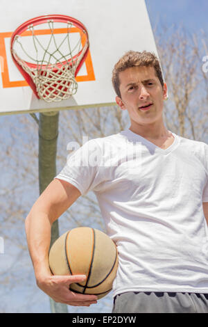 Junger Mann, ruhen Sie sich nach anstrengenden Basketball-Spiel Stockfoto