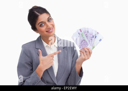 Lächelnde Unternehmerin zeigte auf Geld in der hand Stockfoto