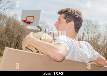 Junger Mann, ruhen Sie sich nach anstrengenden Basketball-Spiel Stockfoto