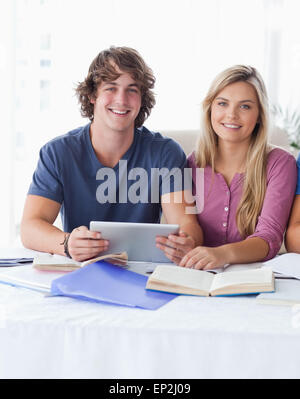 Ein paar halten eine Tablette zusammen beim Blick in die Kamera Stockfoto