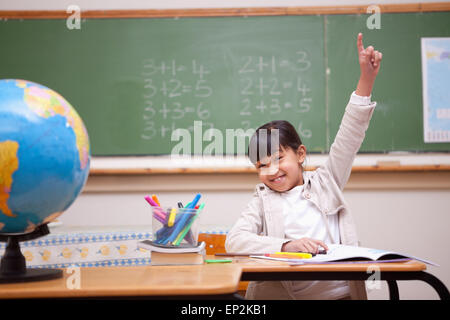 Schulmädchen hob ihre Hand auf eine Frage Antworten Stockfoto