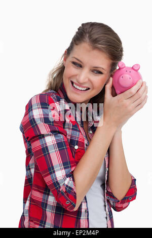 Porträt einer jungen Frau schütteln ein Sparschwein Stockfoto