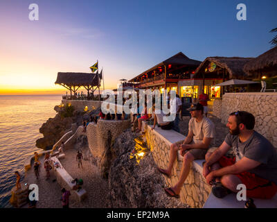 Negril, Jamaika-Menschen in Ricks Cafe an der Küste bei Sonnenuntergang Stockfoto