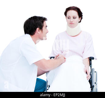 Aufmerksame männlichen Arzt diskutieren mit einem Patienten im Rollstuhl vor einem weißen Hintergrund Stockfoto