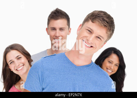 Ein Mann mit seinem Kopf gekippt und seine Freunde hinter ihm lächelnd Stockfoto