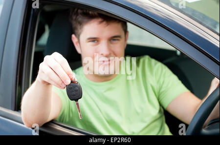 Glücklicher kaukasischen Mann hält einen Autoschlüssel in seinem Auto sitzen Stockfoto