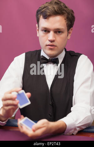 Händler, die sitzen in einem Casino beim Mischen der Karten Stockfoto