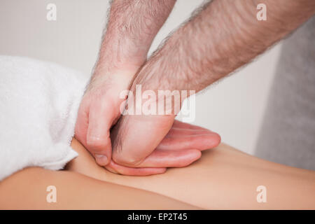 Praktiker, die Massage der Oberschenkel seines Patienten Stockfoto