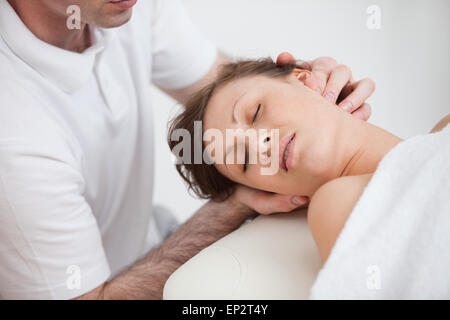 Frau wird vom Arzt massieren, während mit dem Kopf Turn in der Seite Stockfoto