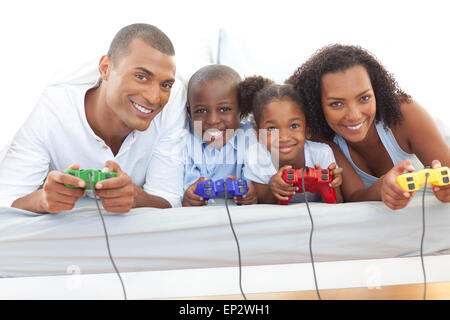 Animierte Familie Videospiel auf Bett liegend Stockfoto