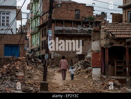 Kathmandu, Nepal. 13. Mai 2015. Die Menschen gehen vorbei an beschädigten Gebäuden in Patan, Nepal, 13. Mai 2015. Die Zahl der Todesopfer in ein frisches mächtig Beben, die Nepal am Dienstag getroffen hat 65 erreicht und mehr als 1.900 weitere wurden verletzt, sagte das Ministerium des Innern am Mittwoch. Bildnachweis: Lui Siu Wai/Xinhua/Alamy Live-Nachrichten Stockfoto