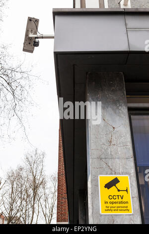 CCTV-Zeichen auf ein Gebäude mit der Überwachungskamera oben, London, England, Großbritannien Stockfoto