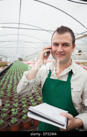 Arbeiter, Notizen und ruft im Gewächshaus Stockfoto