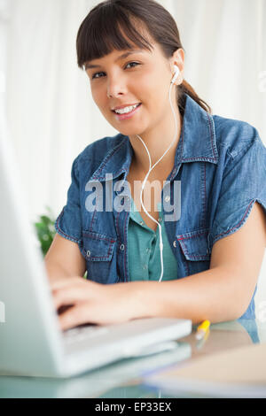 Porträt von einer Studentin, die ihre Hausaufgaben mit Musik Stockfoto