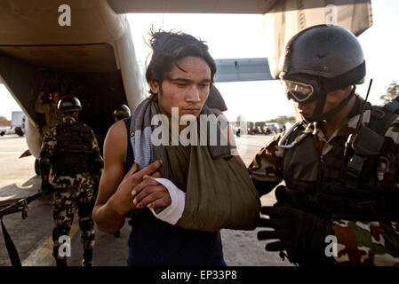 Kathmandu, Nepal. 13. Mai 2015. Ein Soldat der nepalesischen Armee hilft eine Erdbeben-Opfer aus einem US Marine Corps MV-22 Osprey an einem medizinische Triage-Bereich am Tribhuvan International Airport 12. Mai 2015 in Kathmandu, Nepal. Ein 7,3 Größenordnung Nachbeben Erdbeben das Königreich nach dem Erdbeben der Stärke 7,8 am 25. April. Stockfoto