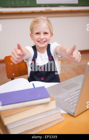 Porträt eines Mädchens mit einem Notebook mit den Daumen bis Stockfoto