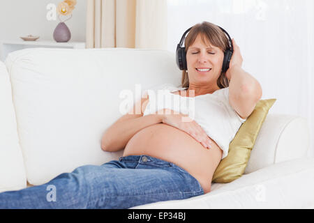 Glücklich schwanger Frau anhören von Musik Stockfoto