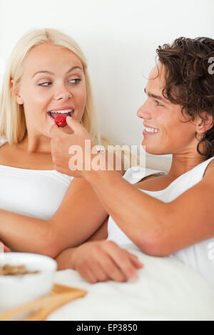 Porträt eines netten Mannes geben eine Erdbeere zu seiner Freundin Stockfoto